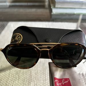Ray-Ban sunglasses with round lenses and gold arms.